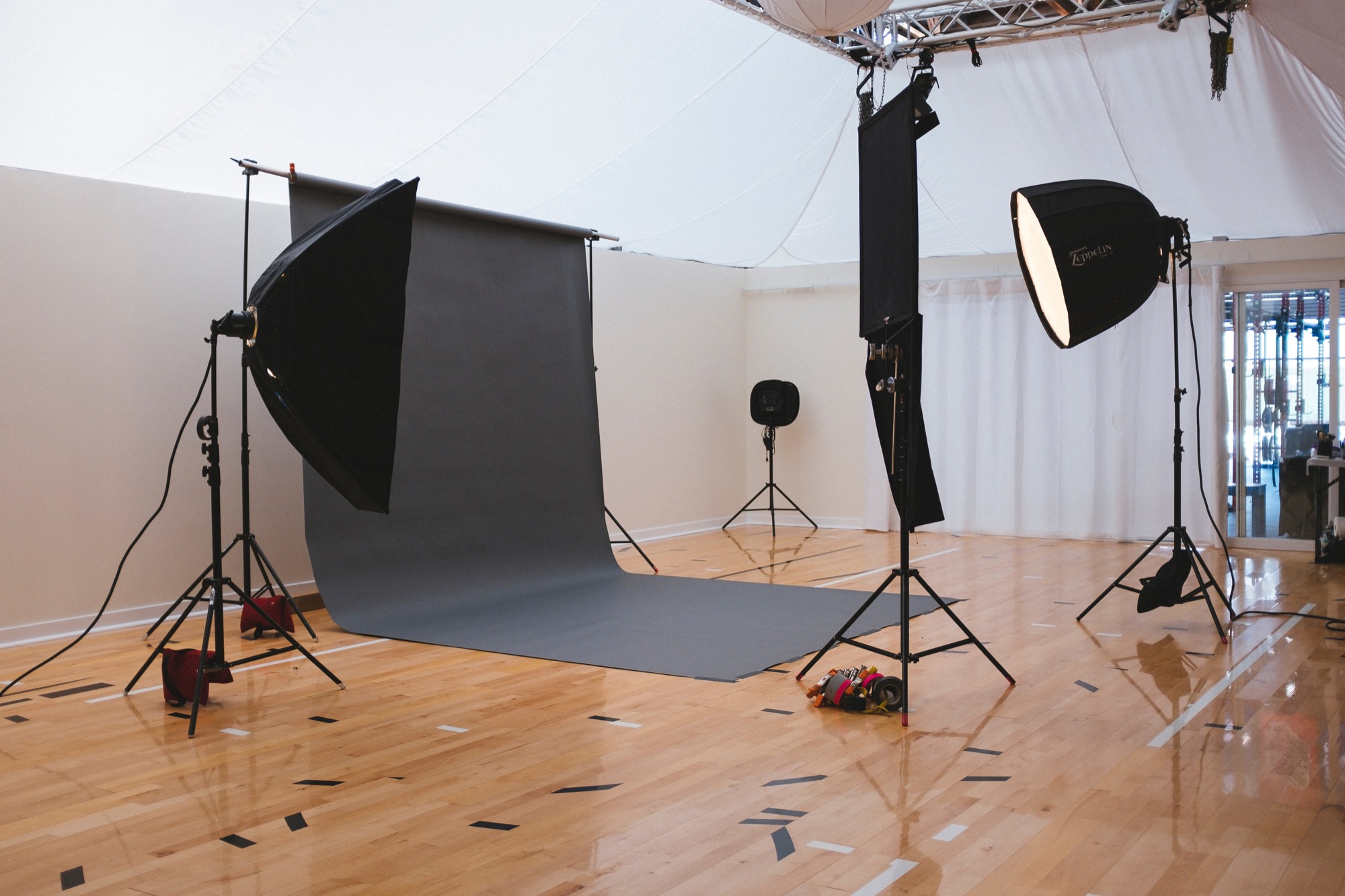 two soft box lights around a black backdrop in a school gym